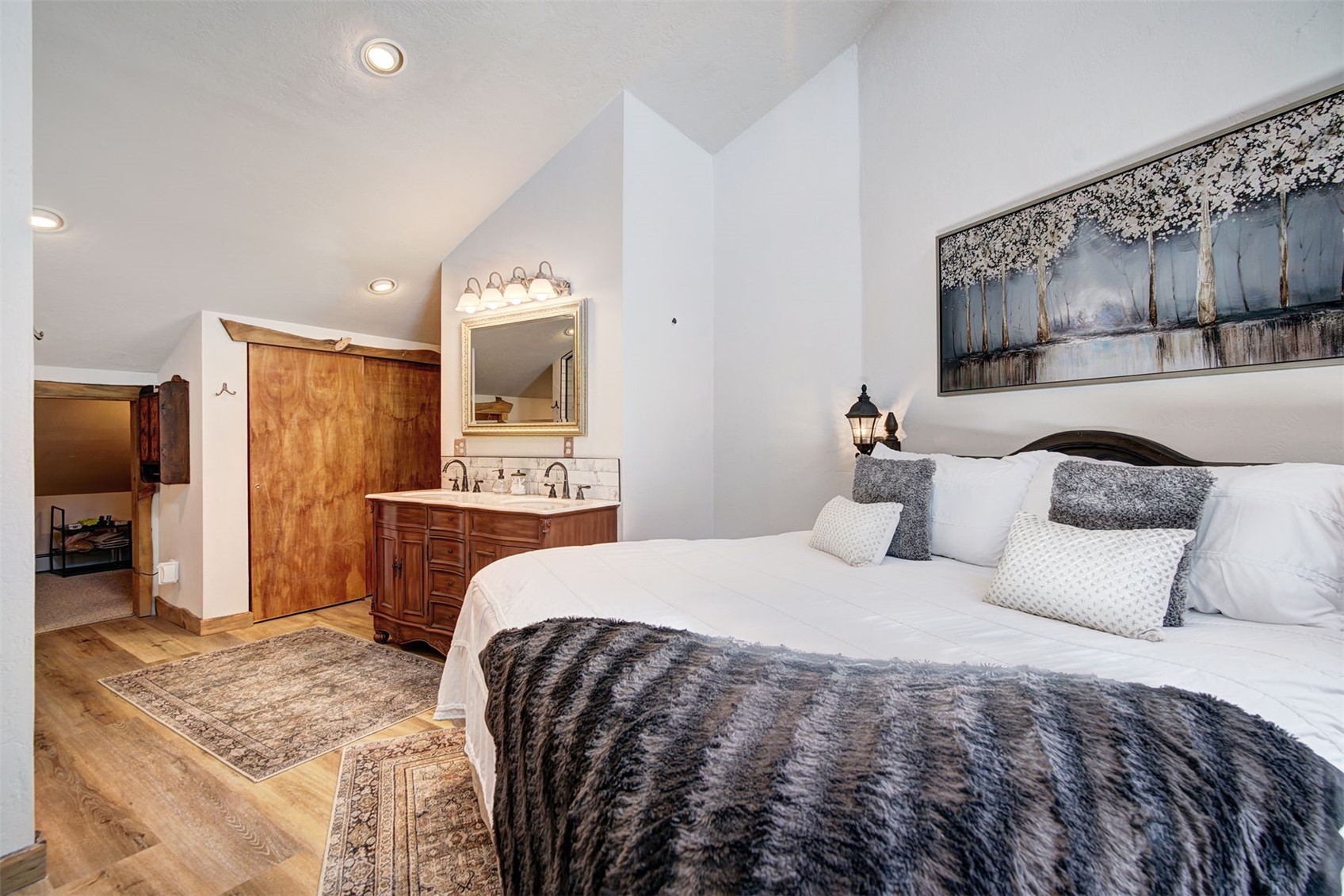 9460 Ryan Gulch Road, Unit 9460 Silverthorne, CO 80498 - Photo 11 of 39 a bedroom with a large bed a flat tv screen and a dresser