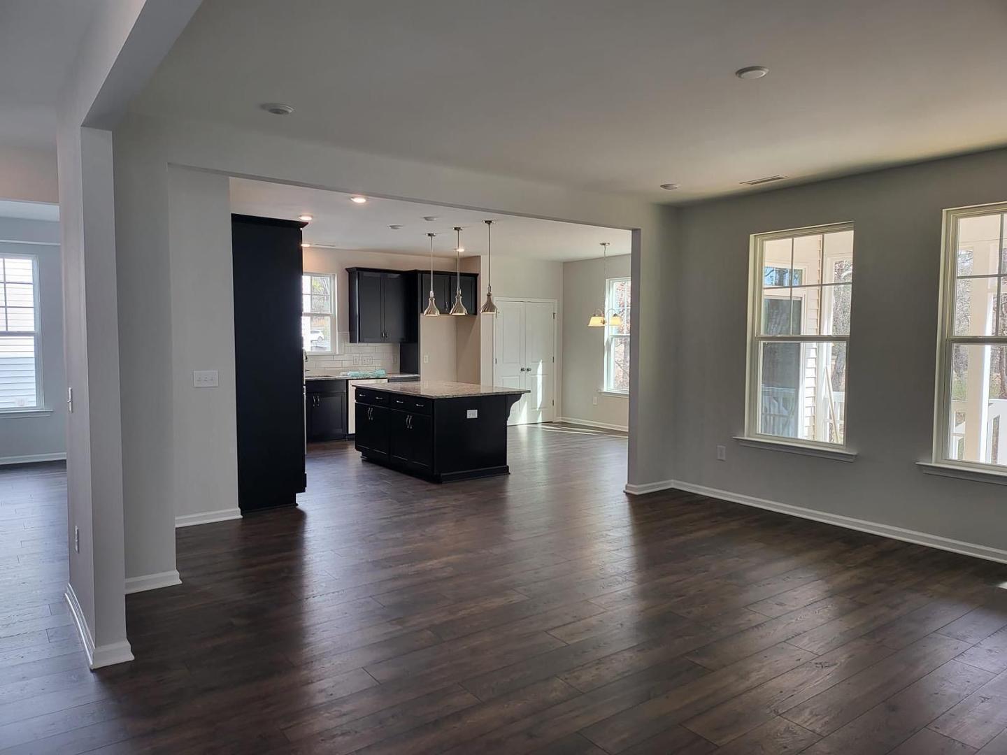 154 Attavar Way Garner, NC 27529 - Photo 13 of 22 a living room with hard wood floors and a kitchen