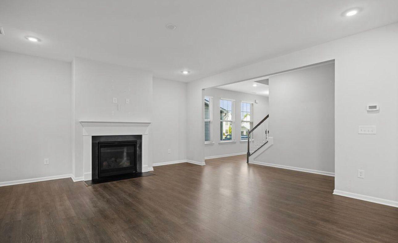 154 Attavar Way Garner, NC 27529 - Photo 19 of 22 a view of an empty room with wooden floor fireplace and a window