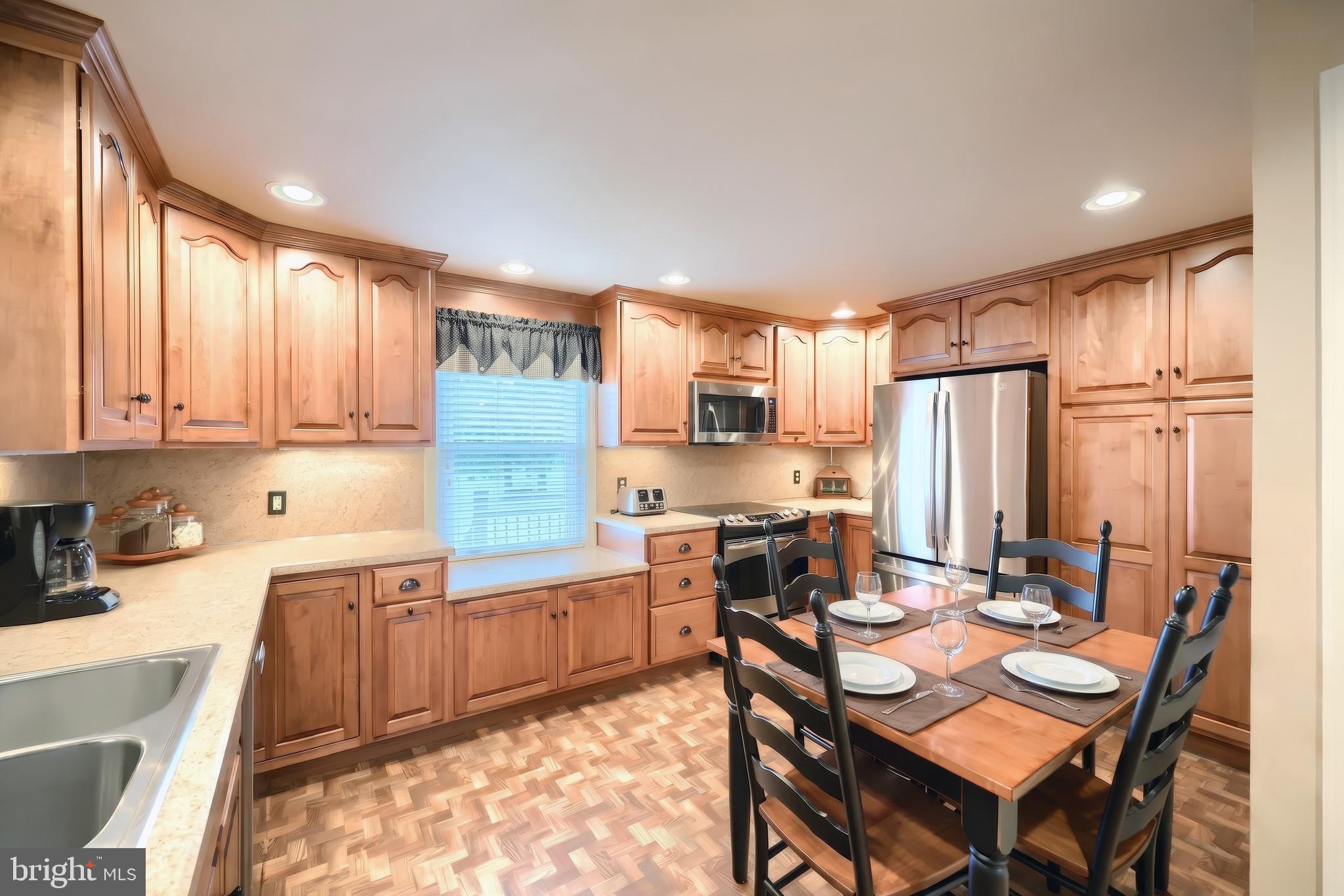 256 North Main Street Manchester, PA 17345 - Photo 8 of 38 a kitchen with stainless steel appliances granite countertop wooden cabinets a dining table and chairs