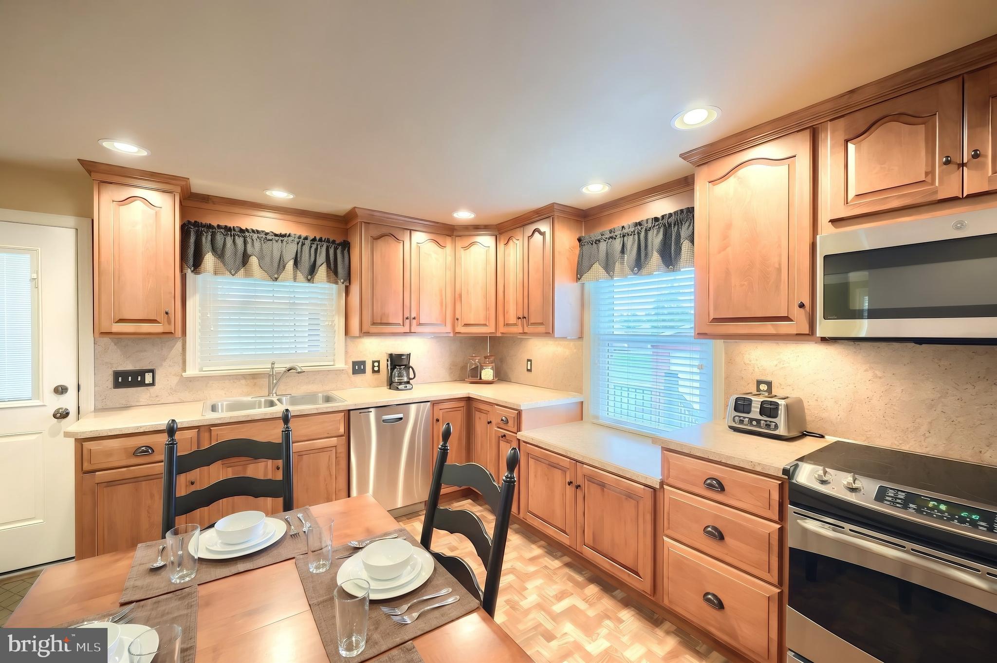 256 North Main Street Manchester, PA 17345 - Photo 9 of 38 a kitchen with stainless steel appliances granite countertop a stove a sink dishwasher and cabinets with wooden floor