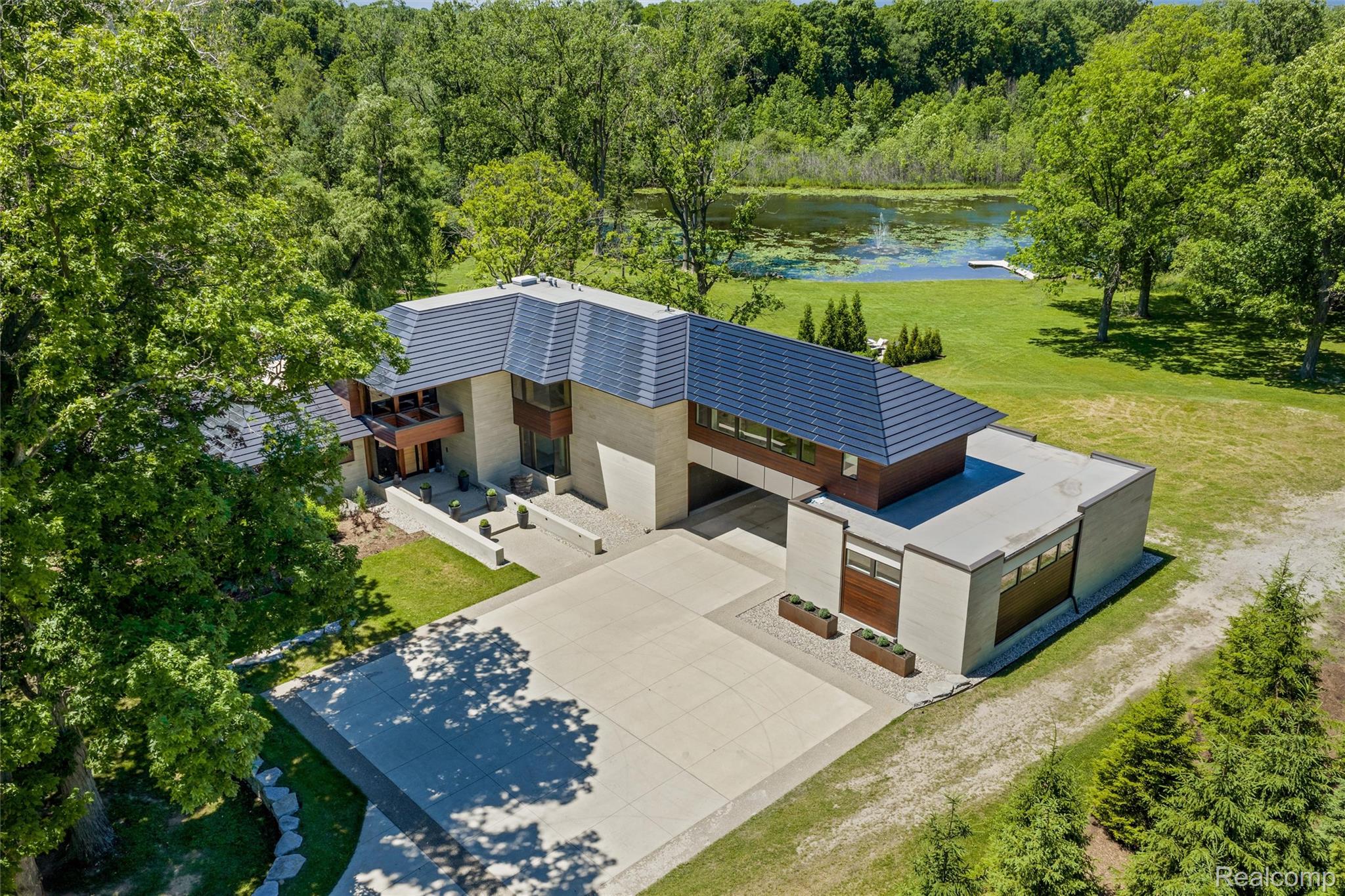2700 Squirrel Road Bloomfield Hills, MI 48304 - Photo 4 of 83 Contemporary residence featuring a multi-level design, a concrete driveway, and a visible body of water