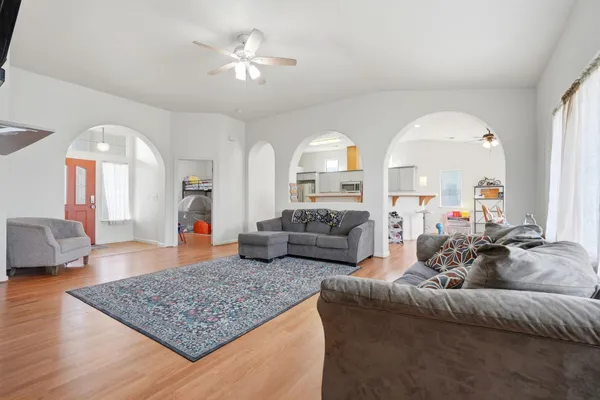 a living room with furniture and a wooden floor