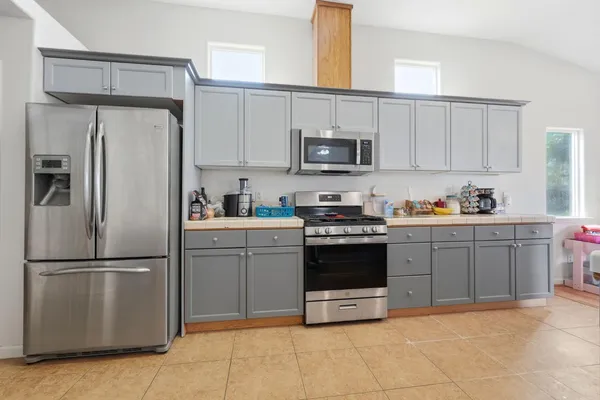 a kitchen with cabinets stainless steel appliances and a counter space