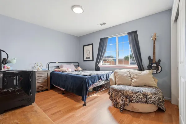 a bedroom with a bed and a flat tv screen on the dresser