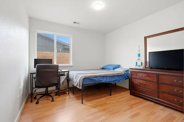 a bedroom with furniture and a flat screen tv