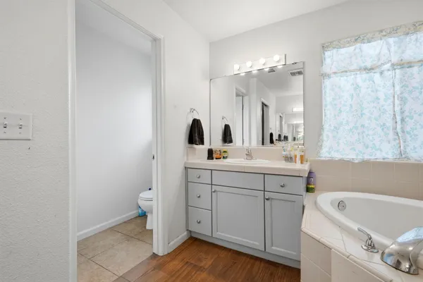 a bathroom with a double vanity sink a mirror and a bathtub