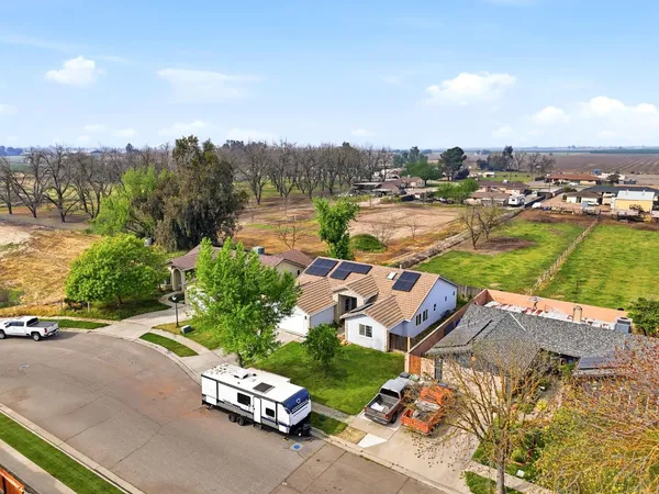 an aerial view of a house with a garden and lake view