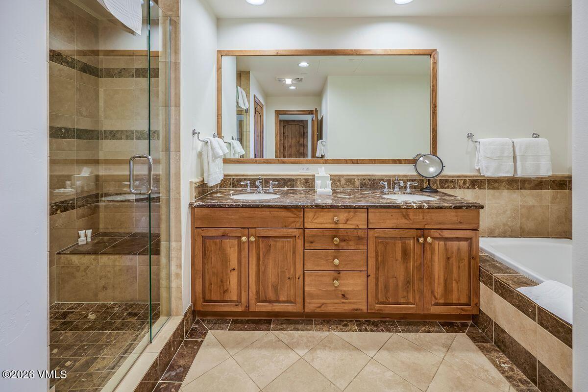 300 Prater Road, Unit A408 Beaver Creek, CO 81620 - Photo 17 of 31 a bathroom with a sink a mirror and a shower