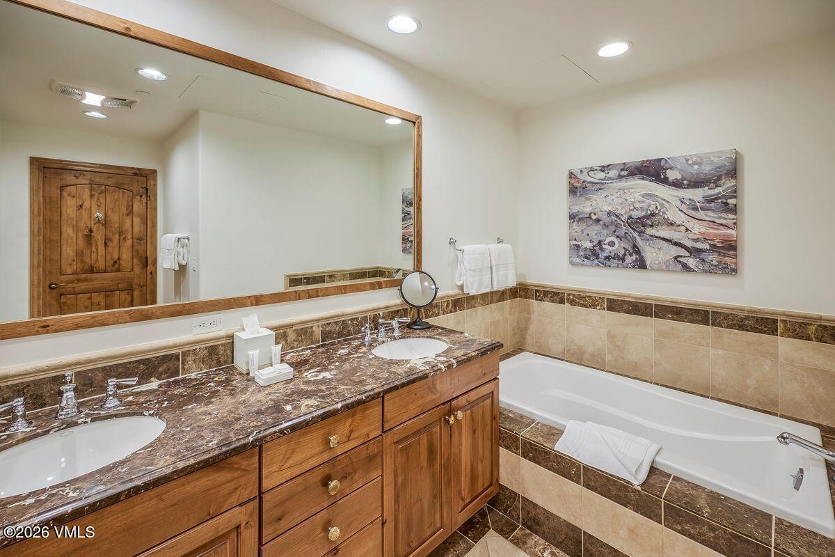 300 Prater Road, Unit A408 Beaver Creek, CO 81620 - Photo 18 of 31 a bathroom with a granite countertop sink mirror and bathtub