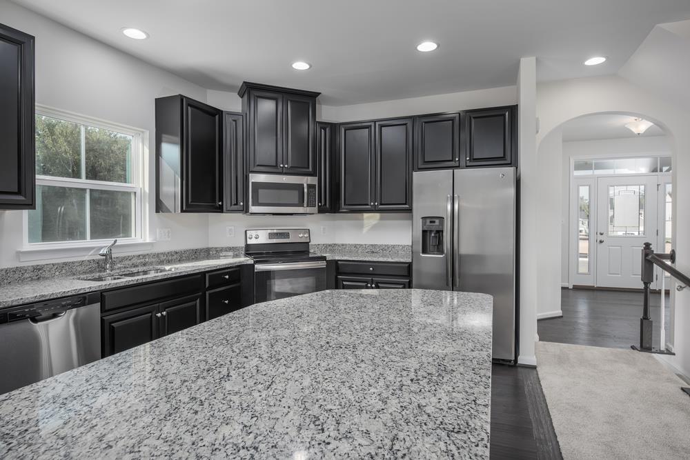 1042 Oglethorpe Drive Franklin, TN 37064 - Photo 4 of 30 a kitchen with stainless steel appliances granite countertop a refrigerator a sink a stove a microwave and wooden cabinets