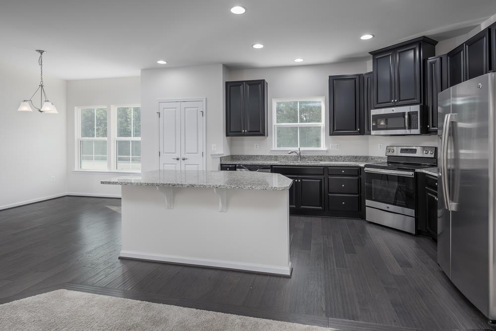 1042 Oglethorpe Drive Franklin, TN 37064 - Photo 5 of 30 a kitchen with stainless steel appliances granite countertop wooden cabinets a refrigerator a sink a stove a microwave and wooden floors