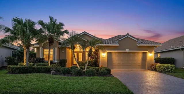 a front view of a house with a garden and yard