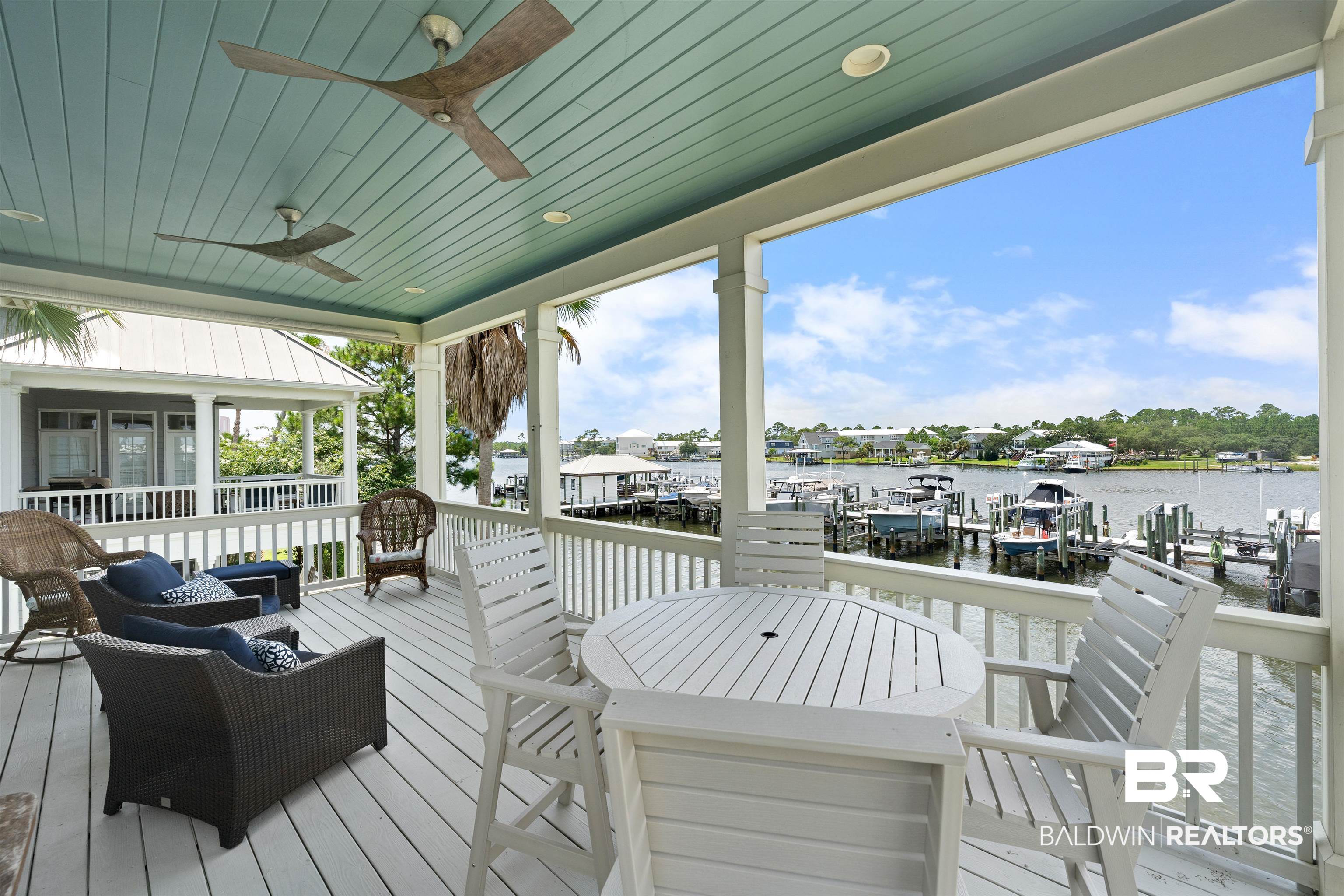 3434 Mariner Circle Orange Beach, AL 36561 - Photo 8 of 38 Deck featuring a dock, a water view, ceiling fan, and an outdoor hangout area.