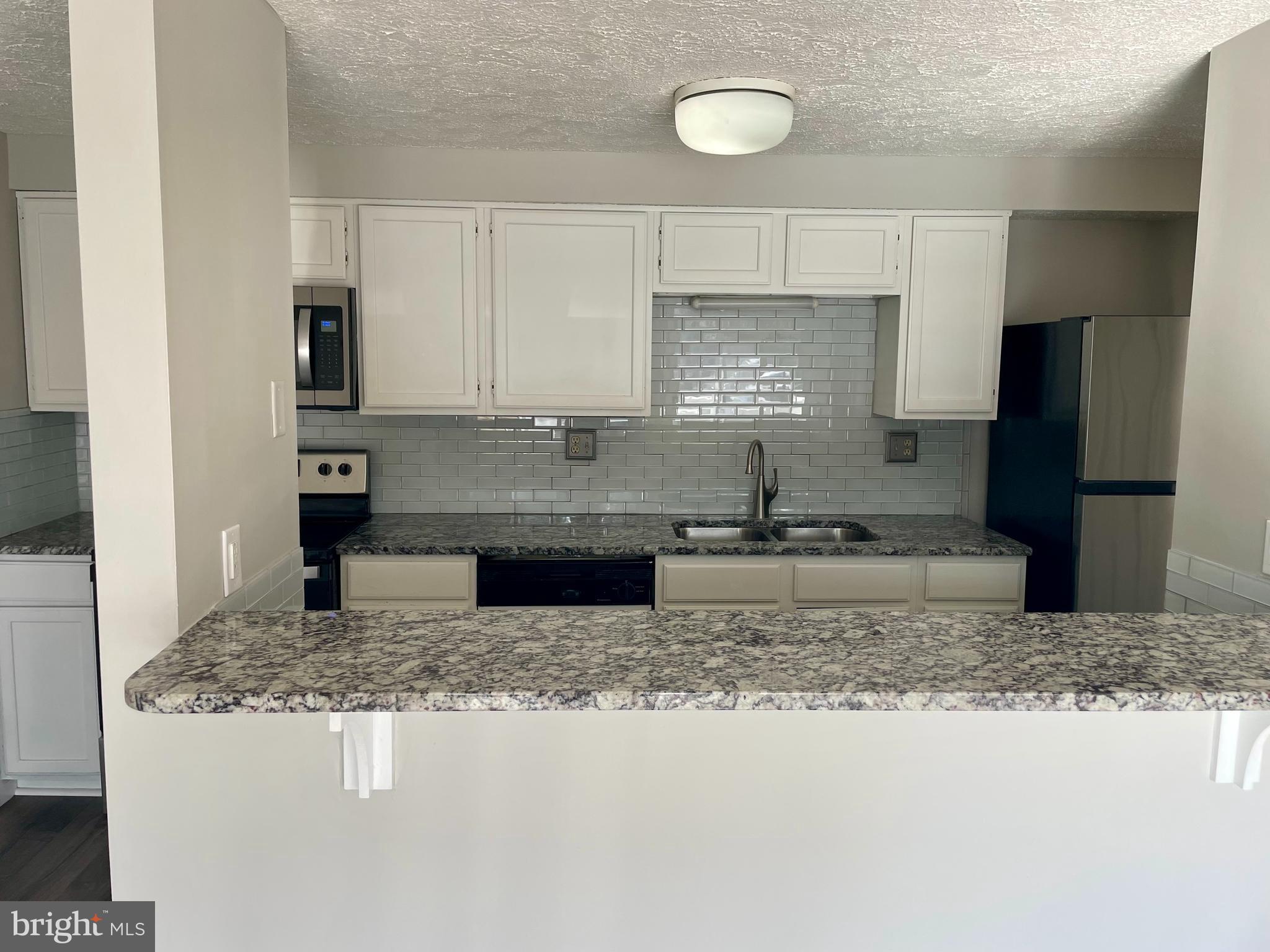 17 Cranberry Court Marlton, NJ 08053 - Photo 7 of 17 a kitchen with kitchen island granite countertop a sink a counter top space and cabinets