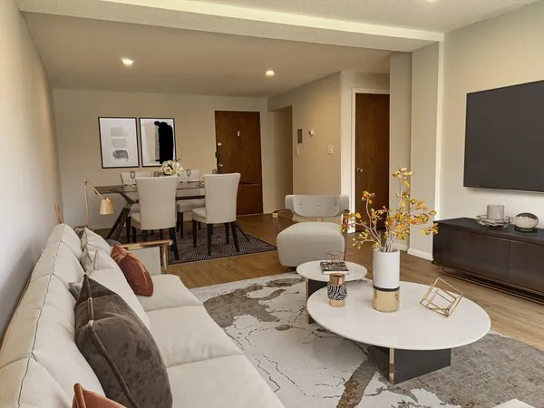 a living room with furniture a flat screen tv and kitchen view