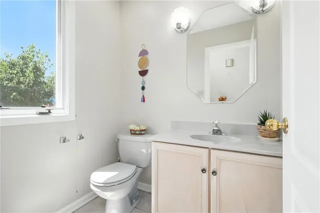 a bathroom with a granite countertop sink and a toilet