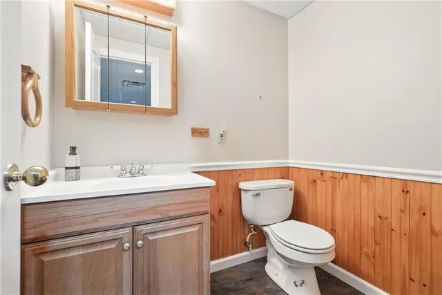 a bathroom with a toilet a sink and mirror