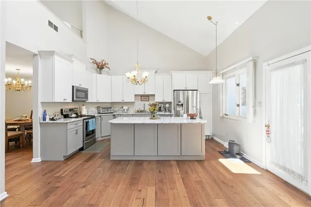 a kitchen with a sink cabinets stainless steel appliances and wooden floor