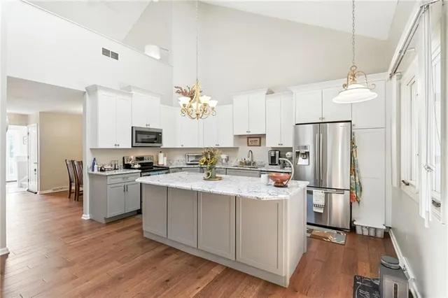 a kitchen with stainless steel appliances a sink stove refrigerator and cabinets