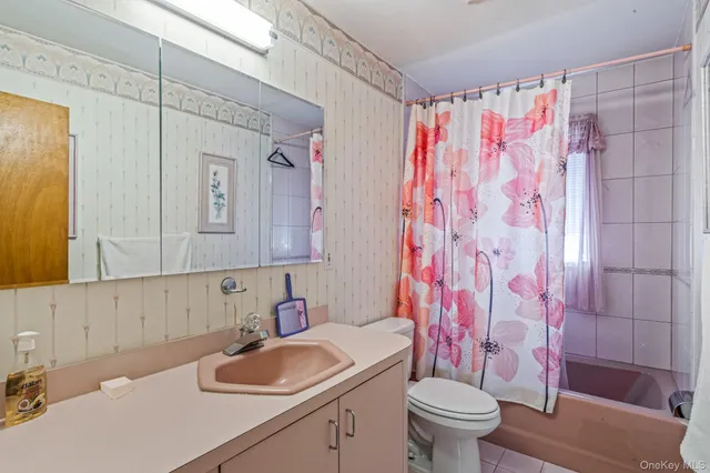 a bathroom with a sink a toilet and shower curtain