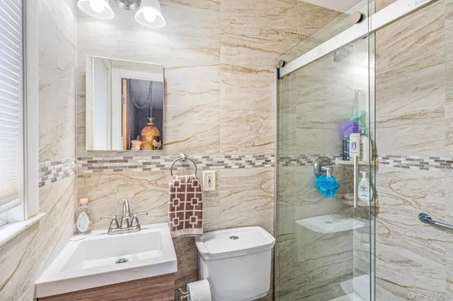 a bathroom with a sink a toilet and shower