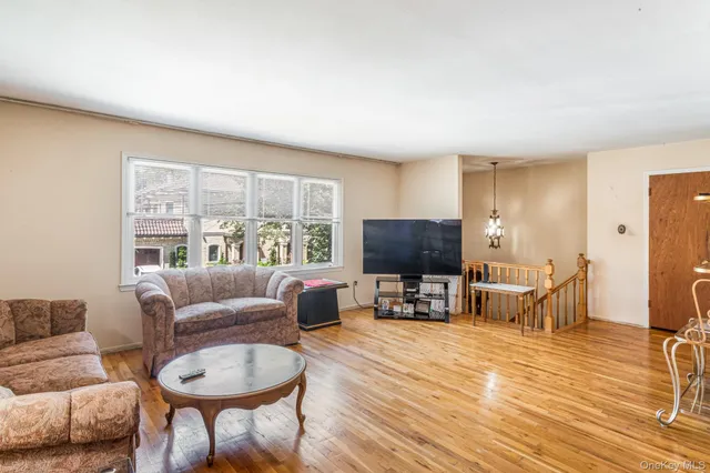 a living room with furniture a flat screen tv and a large window