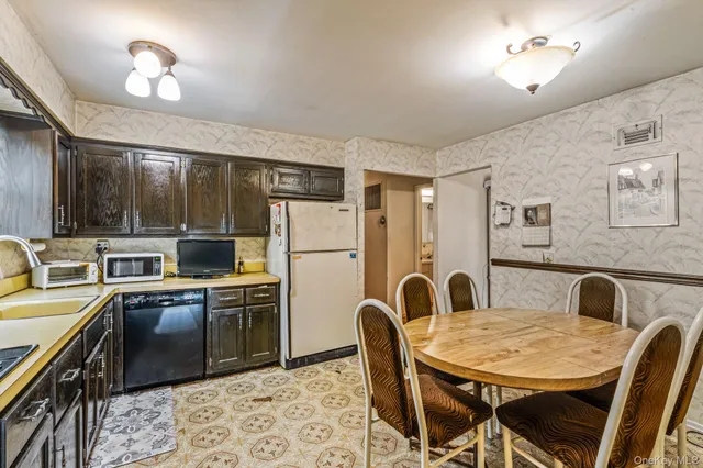 a kitchen with stainless steel appliances granite countertop a stove a refrigerator a kitchen island a dining table and chairs with wooden floor