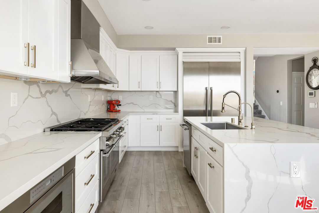 11540 Apulia Court Porter Ranch, CA 91326 - Photo 5 of 25 a kitchen with stainless steel appliances granite countertop a sink stove and cabinets