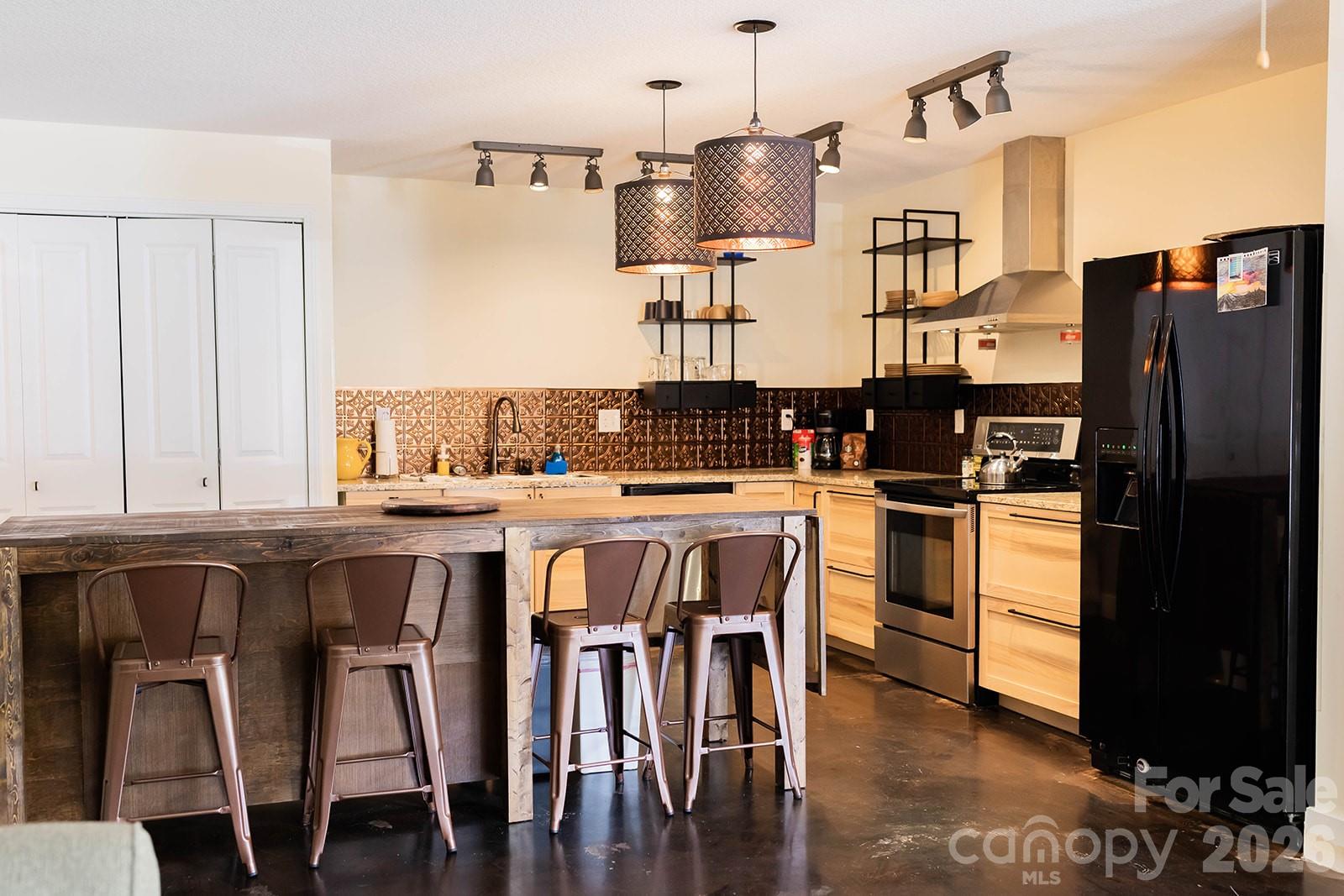 309 London Road Asheville, NC 28803 - Photo 16 of 41 a kitchen with stainless steel appliances granite countertop a stove a refrigerator a sink counter tops and chairs