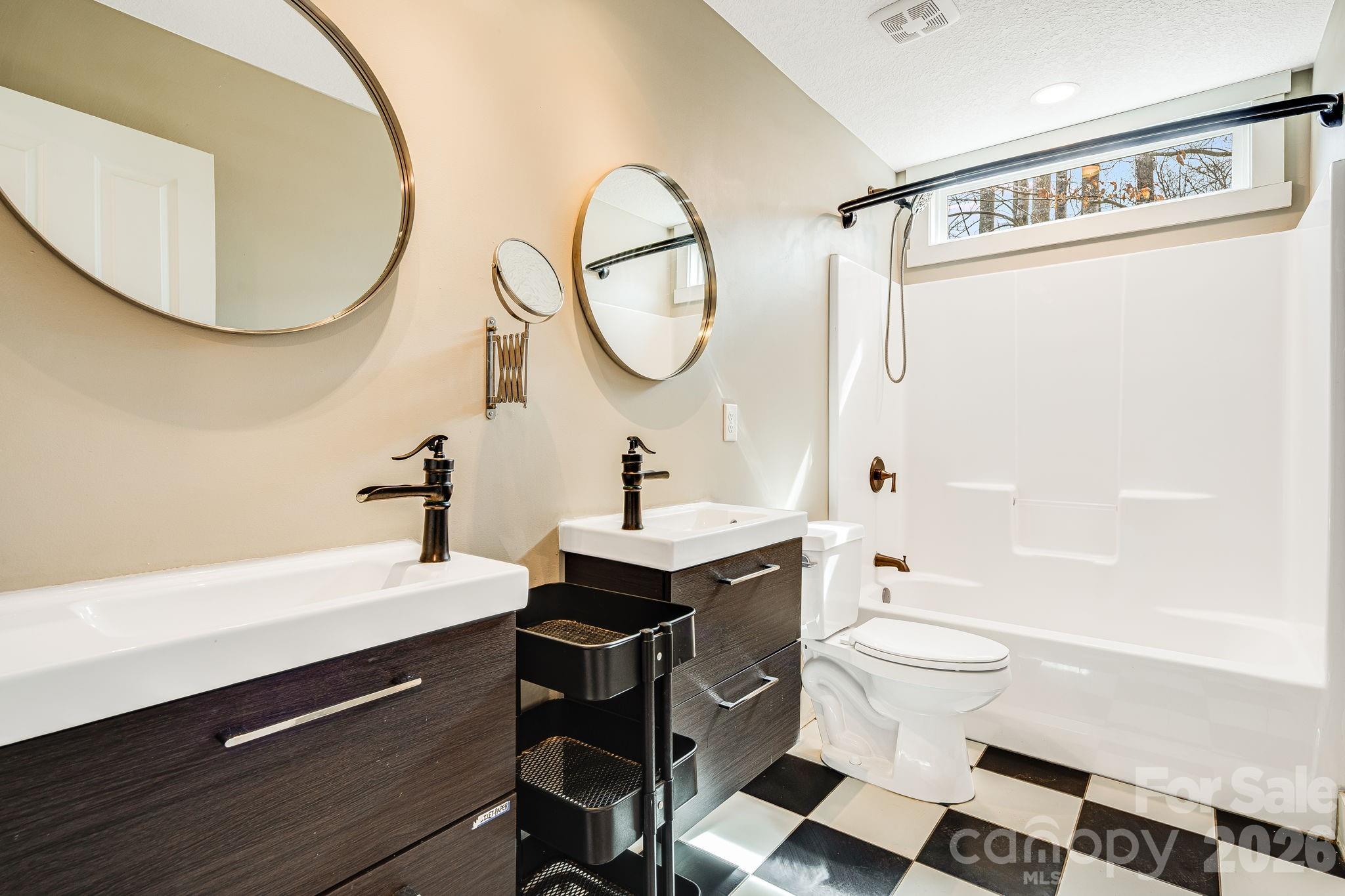 309 London Road Asheville, NC 28803 - Photo 29 of 41 a bathroom with a sink a mirror a toilet and a shower