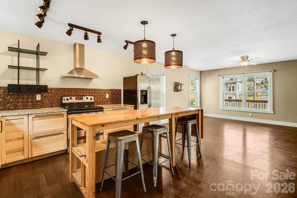 a kitchen with stainless steel appliances granite countertop a stove and white cabinets