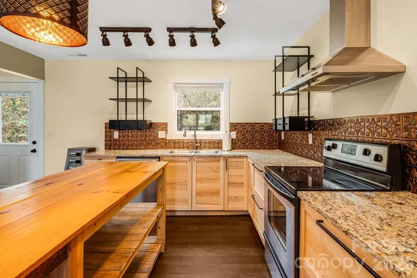 a kitchen with stainless steel appliances granite countertop a sink and stove