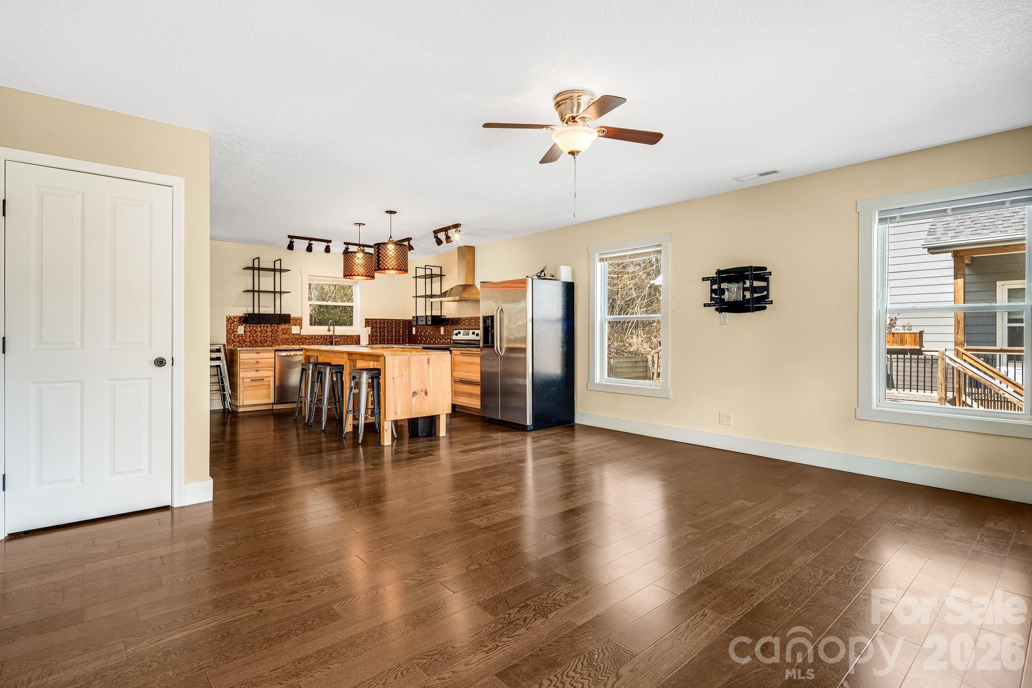309 London Road Asheville, NC 28803 - Photo 9 of 41 a dining room with wooden floor a chandelier a glass table and chairs