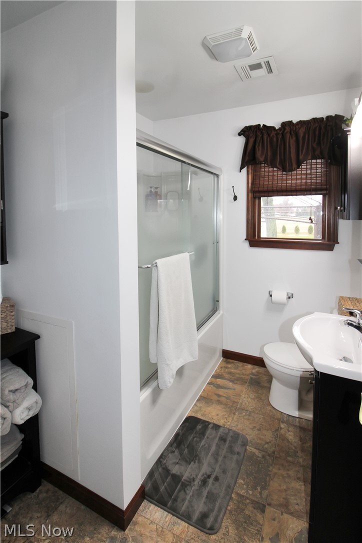 38 Meachem Road Port Clinton, OH 43452 - Photo 3 of 35 Full bathroom featuring vanity, toilet, tile flooring, and shower / bath combination with glass door
