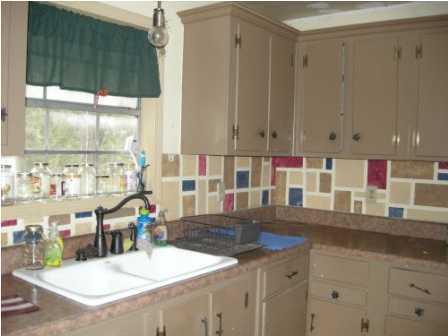 4858 Hinote Road DeFuniak Springs, FL 32433 - Photo 12 of 27 a kitchen with stainless steel appliances kitchen island granite countertop a sink and cabinets