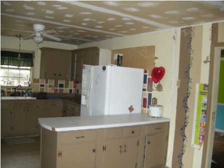 4858 Hinote Road DeFuniak Springs, FL 32433 - Photo 14 of 27 a kitchen with a sink a refrigerator and wooden cabinets