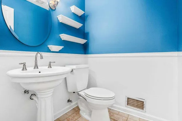 a bathroom with a sink a mirror and toilet