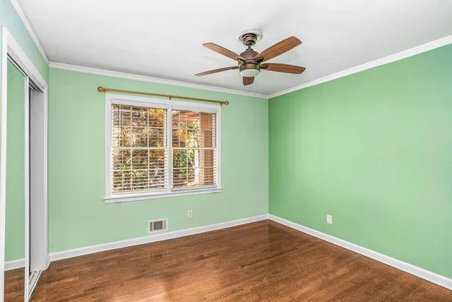 a view of a big room with wooden floor and windows