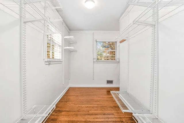 a view of a room with wooden floor and window