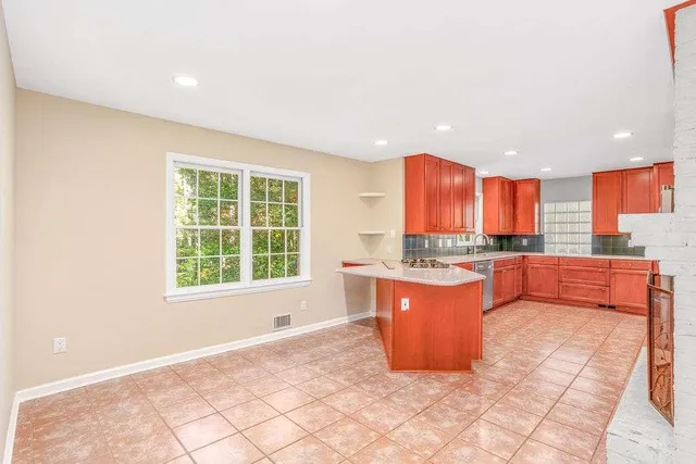 a large room with kitchen island granite countertop a large window and a sink