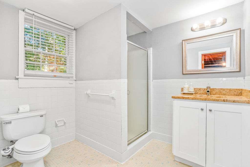 3911 Ivy Road Northeast Atlanta, GA 30342 - Photo 24 of 28 a bathroom with a toilet a sink and a window