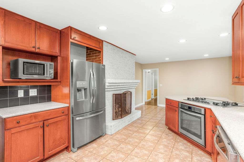 3911 Ivy Road Northeast Atlanta, GA 30342 - Photo 4 of 28 a kitchen with stainless steel appliances granite countertop a stove a refrigerator and a microwave