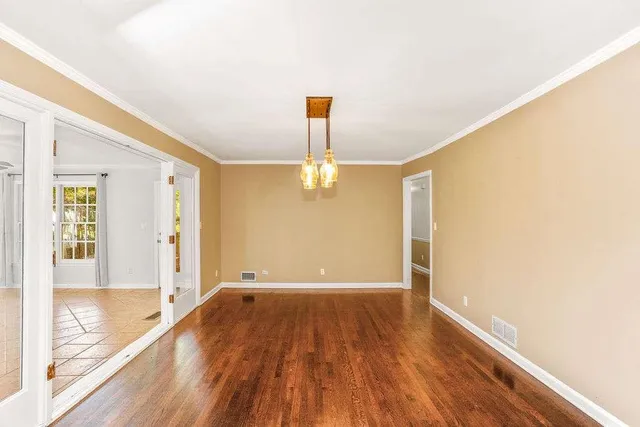 a view of empty room with wooden floor