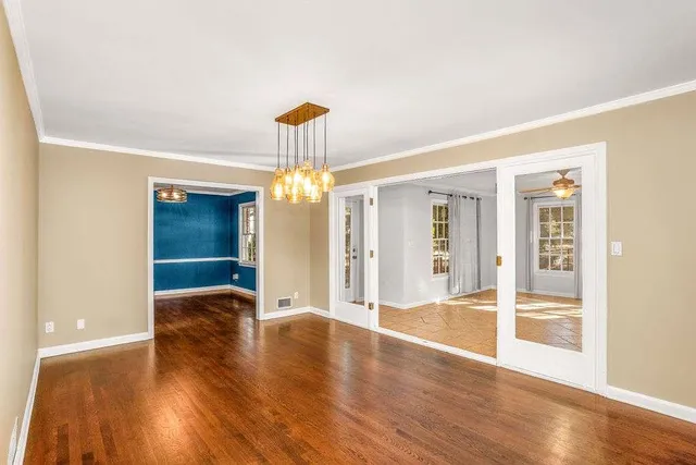 a view of an empty room with wooden floor