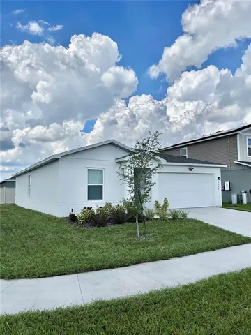 a view of a white house next to a yard