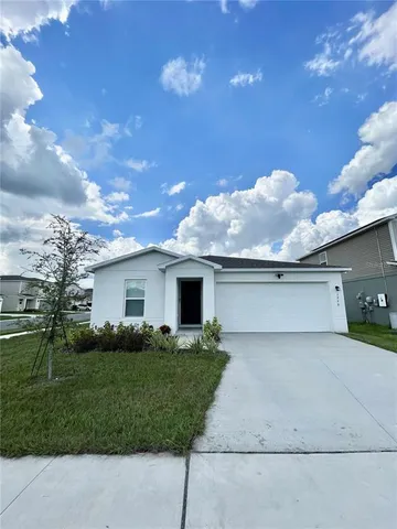 a front view of house with yard and trees