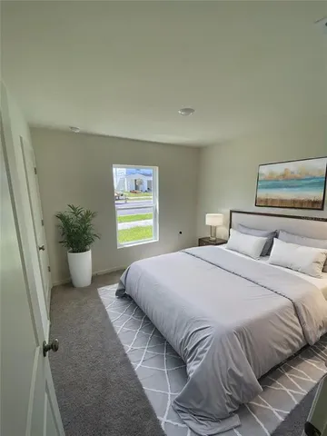 a bedroom with a bed and a potted plant