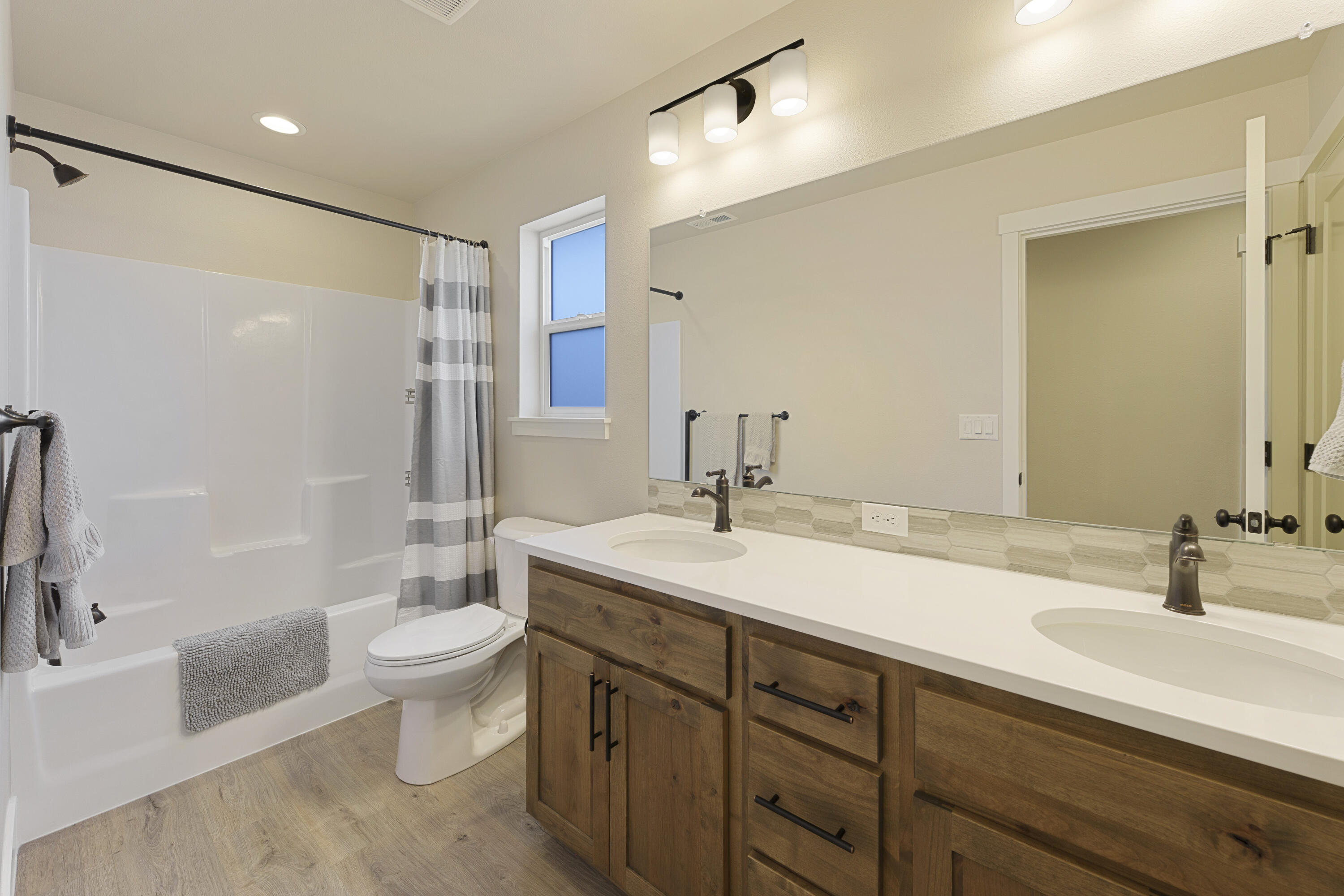 4999 Southwest Yew Place Redmond, OR 97756 - Photo 30 of 50 a bathroom with a double vanity sink toilet mirror and bathtub