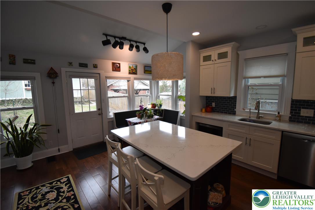715 Coleman Street Easton, PA 18042 - Photo 11 of 38 a kitchen with stainless steel appliances granite countertop a stove a sink dishwasher a dining table and chairs with wooden floor